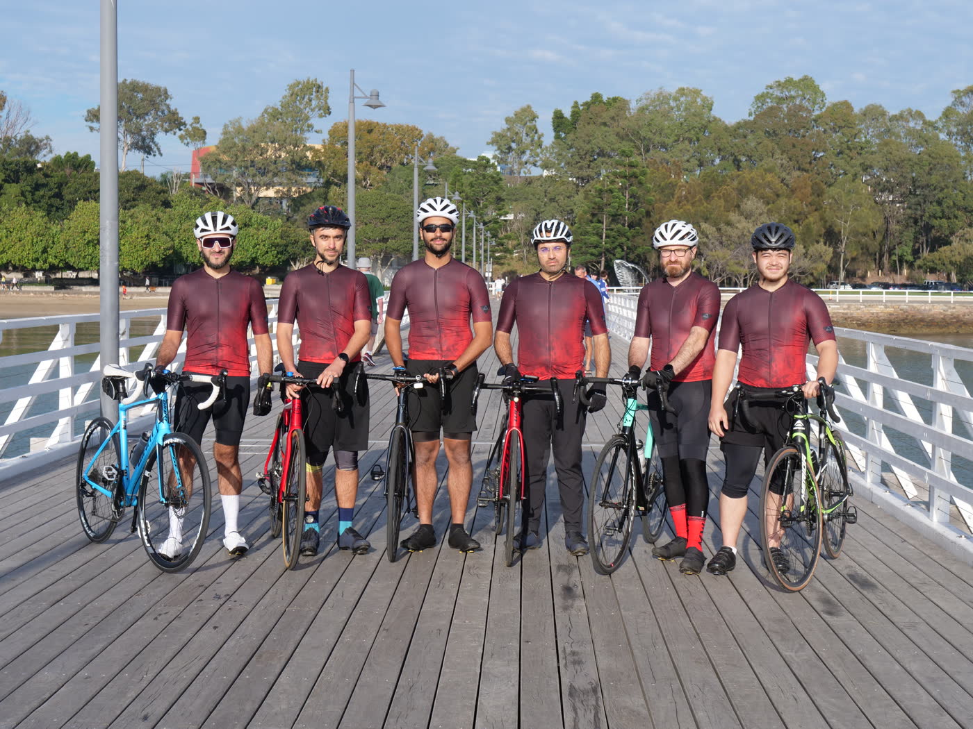 Six Cycle of Hope riders with their bikes on a Brisbane pier, photographed by 777 Media for the charity campaign